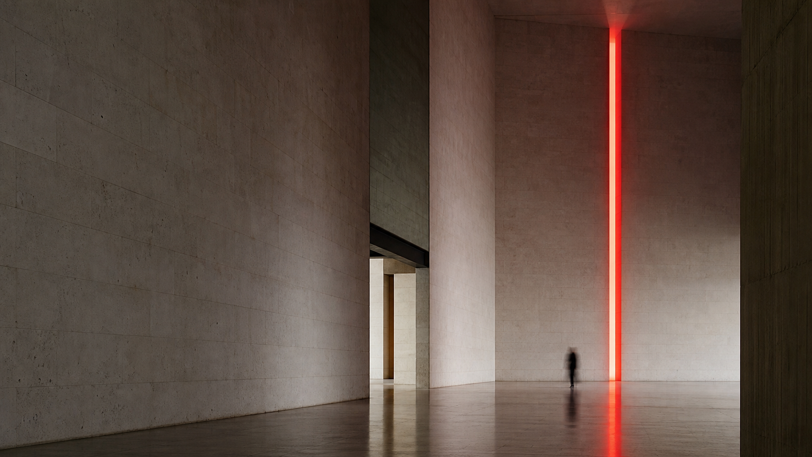 A monumental stone atrium marked by a single vertical red beam